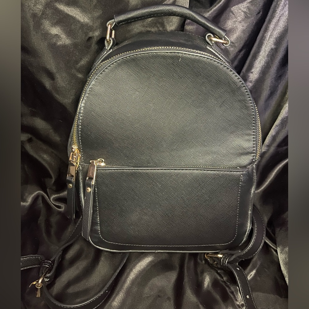Simple Black backpack purse with gold hardware. Used.